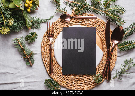 Elegant Christmas  or thanksgiving place settings with empty menu on the dish and golden cutlery. Table decorated for the dinner holiday Stock Photo