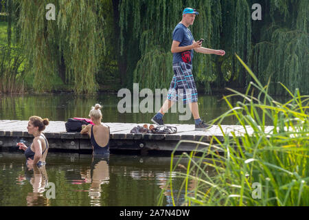 Prague Park summer Two women bathing, a man walking a wooden bridge, in the city park Stromovka Prague Czech Republic summer Stromovka park Stock Photo