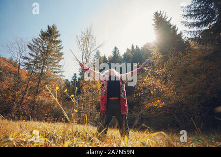 Homeless man in torn sweater celebrating life holding his violin standing in golden autumn nature. Stock Photo