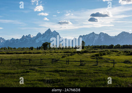 Fields with Grand Teton mountains in distance Stock Photo