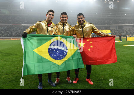 --FILE--Brazilian football player Elkeson de Oliveira Cardoso, or simply Elkeson, middle, raises Chinese and Brizilian flags to celebrate at the award Stock Photo