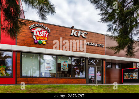 Coina, Portugal. Entrance of KFC fast food restaurant with an ad for the Tasty World children area (Área Infantil in Portuguese).Kentuky Fried Chicken Stock Photo