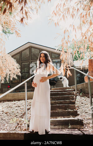 Pregnant woman white dress outside Stock Photo