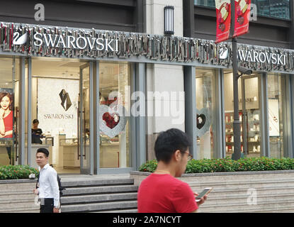 --FILE--Pedestrians walk past a boutique store of Swarovski in Shanghai, China, 30 August 2017. Coach, Versace, Givenchy and Swarovski have since issu Stock Photo