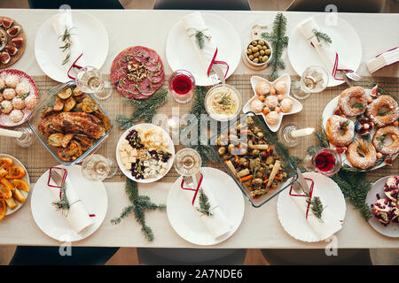 Top view background of beautiful Christmas table with delicious homemade food decorated with fir branches, copy space Stock Photo