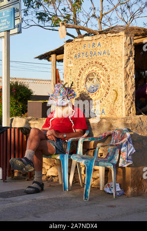Hippy Painter artist, named Firefox, resting at the entrance to the hippie flea market at El Pilar de la Mola (Formentera, Balearic Islands, Spain) Stock Photo