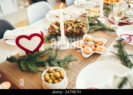 Background image of cozy table setting decorated with fir branches for Christmas banquet focus on freshly baked pastries, copy space Stock Photo