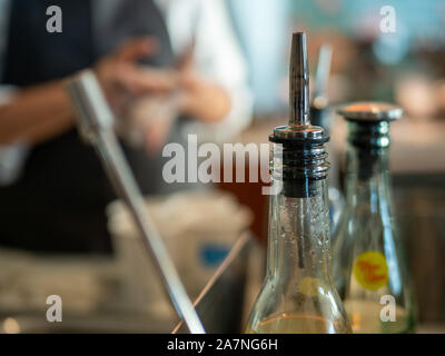 Nozzle of juice bottle sitting on counter of coffee shop with barista in background Stock Photo