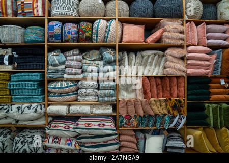 Collection of various throw pillows, baskets and home decorations on shelf inside storage of store Stock Photo