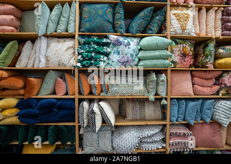 Collection of various throw pillows and decorative pillows on shelf inside storage of store Stock Photo