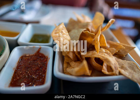 Close up of gourmet tortilla chips next to various salsa dips in Mexican restaurant Stock Photo
