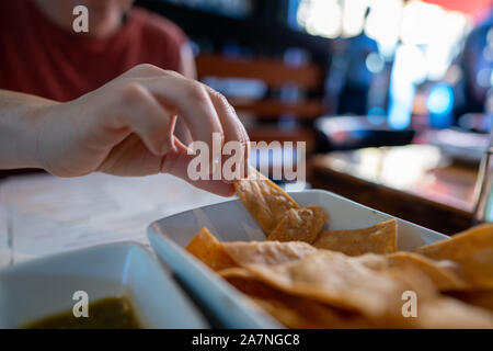 Woman hand grabbing gourmet tortilla at table of Mexican restaurant Stock Photo