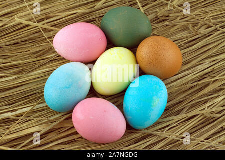 Colorful Easter eggs on straw background closeup Stock Photo