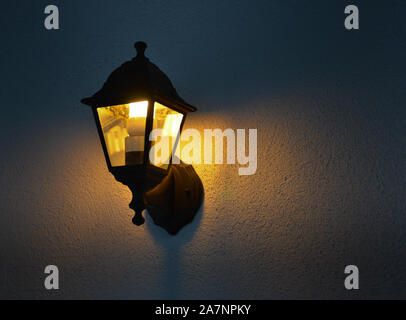 Low angle view of illuminated vintage lamp mounted on wall Stock Photo