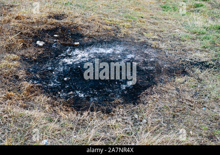 Traces of ash and charcoal grill  after a barbeque  fire in nature during   summer Stock Photo