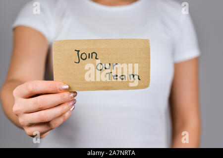 Close up of  young women hand  holding cardboard paper with  Join our Team sentence text . Stock Photo