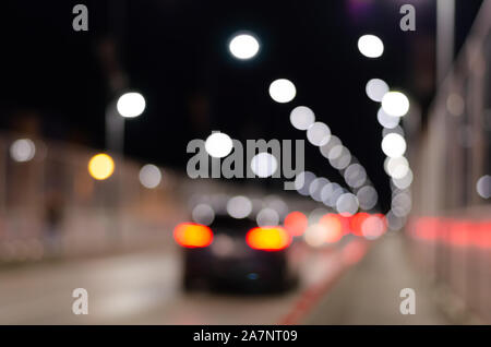Blurred  city highway  with multicolored  brightly glowing street lights and moving cars during the night . Stock Photo