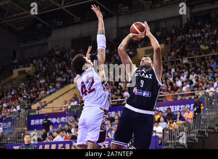 A basketball player of Greece, right, jumps to shoot while defended by a member of Venezuela, left, during 2019 Suzhou International Basketball Challe Stock Photo