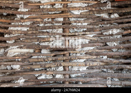 Old wall made of wooden sticks and cement Stock Photo