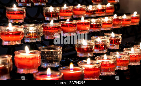 Burning candles in a straight line with a black background Stock Photo