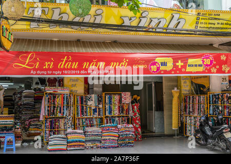 Da Nang, Vietnam - March 10, 2019: Giant mix of colors at fabric store where all mechandise is displayed outside and inside, and with large inscriptio Stock Photo