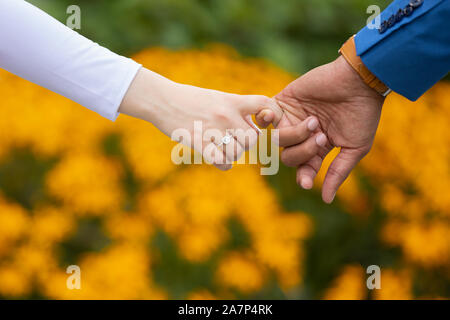 Hands of couple holding each other Stock Photo