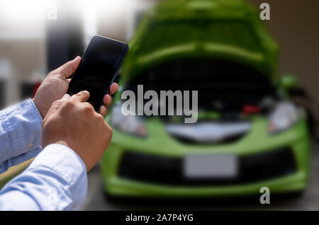man Using a mobile phone call to  assistance Help with a broken down car assist stop car roadside breakdown Stock Photo