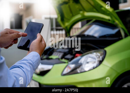 man Using a mobile phone call to  assistance Help with a broken down car assist stop car roadside breakdown Stock Photo