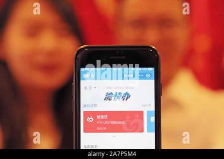 A couple shows their digital marriage certificates on their smartphone at a civil affairs office on the traditional Chinese festival Qixi Festival, al Stock Photo