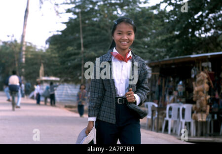 A young, indigenous Mnong (Pnong) girl walks through her village on her way to work. Mondulkiri Province, Cambodia. Stock Photo