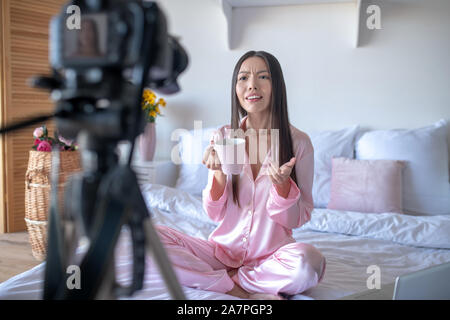Blogger drinking coffee and filming blog in the morning Stock Photo