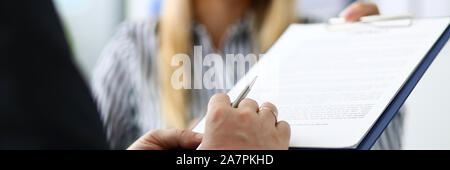 Smiling female real estate agent offering male visitor document to sign Stock Photo