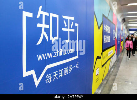 --FILE--Local residents walk past an advertisement for China's largest question-and-answer platform Zhihu in Nanjing city, east China's Jiangsu provin Stock Photo