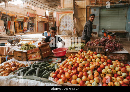 Rissani, Morocco - September 18th, 2019: Two men selling vegetables at the food market in Rissani, Morocco Stock Photo