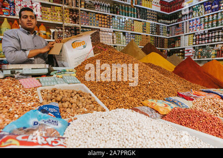 Rissani, Morocco - September 18th, 2019: Traditional stall with spices and herbs, and seller talking to the tourists, at the food market of Rissani Stock Photo