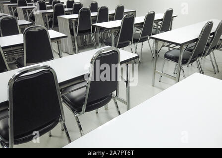Empty nobody chairs and desks in classroom background. Stock Photo