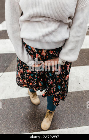 Portrait of beautiful pregnant woman. She is standing in the middle of the street and holding hands on her belly. Stock Photo
