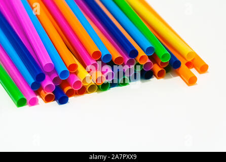 group of plastic straws of various colors on a white background. Global warming and plastic pollution. Environmental issues. Party and refreshment. Stock Photo