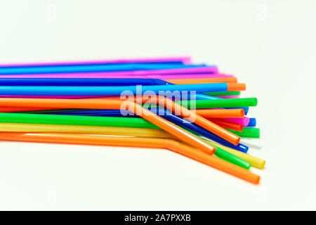 group of plastic straws of various colors on a white background. Global warming and plastic pollution. Environmental issues. Party and refreshment. Stock Photo