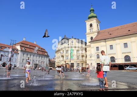 SIBIU, ROMANIA - AUGUST 24, 2012: People visit main square in Sibiu. Romania had 1,911,800 foreign visitors in 2014. Stock Photo