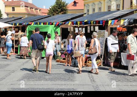 SIBIU, ROMANIA - AUGUST 24, 2012: People visit medieval fair main square in Sibiu. Romania had 1,911,800 foreign visitors in 2014. Stock Photo