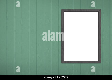 empty blank white mock up picture frame board on green wood panels wall background. Stock Photo