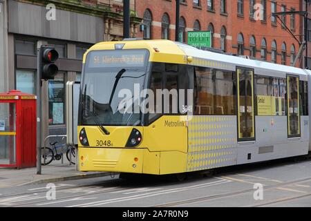 MANCHESTER, UK - APRIL 21, 2013: People ride Manchester tram in Manchester, UK. Manchester Metrolink serves 21 million rides annually (2011). Stock Photo