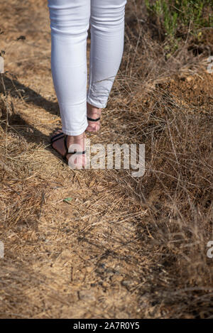Rear view of young woman walking away in the field Stock Photo