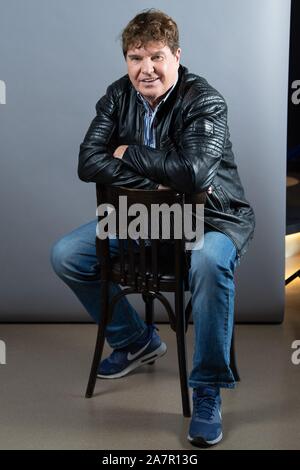 Dresden, Germany. 30th Oct, 2019. The singer Frank Schöbel sits in front of a photo wall in the boulevard theatre. The occasion is the presentation of the musical 'Frank Schöbel Story', which deals with the career of the GDR hit singer Frank Schöbel on stage. Credit: Sebastian Kahnert/dpa-Zentralbild/dpa/Alamy Live News Stock Photo