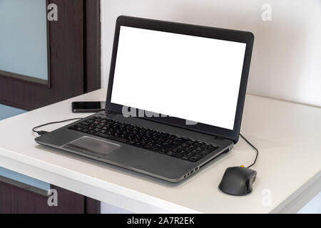 Person working on a laptop in a business office enviroment. Over the shoulder shot of man typing on a computer with blank screen. Stock Photo