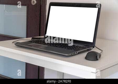 Person working on a laptop in a business office enviroment. Over the shoulder shot of man typing on a computer with blank screen. Stock Photo
