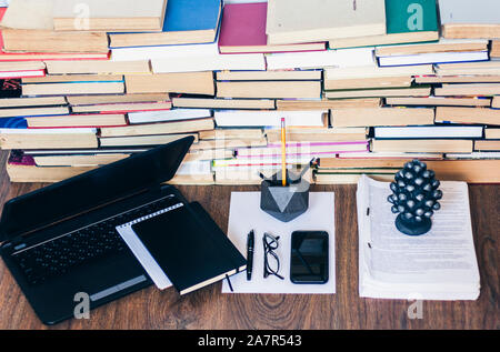 Open textbook, notebook, smartphone, laptop computer, stack of books education back to school background, paperweight, documents, glasses and pencils Stock Photo