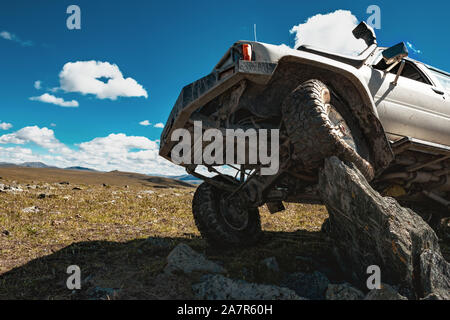 4x4 offroad car stands on big rock Stock Photo
