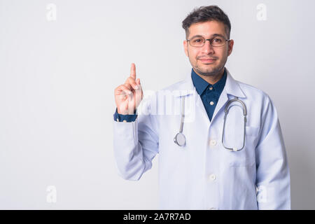 Portrait of young Persian man doctor pointing up Stock Photo